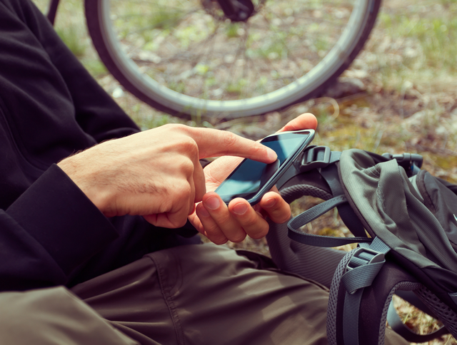 7 велосипедист ищет GPS-координаты на мобильном телефоне в лесу