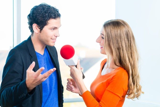 Женщина берет интервью у мужчины с микрофоном