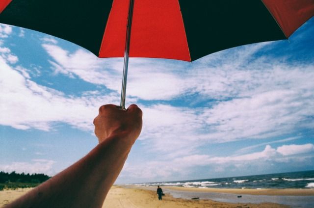 Зонт в руке на пляже http://barnimages.com/