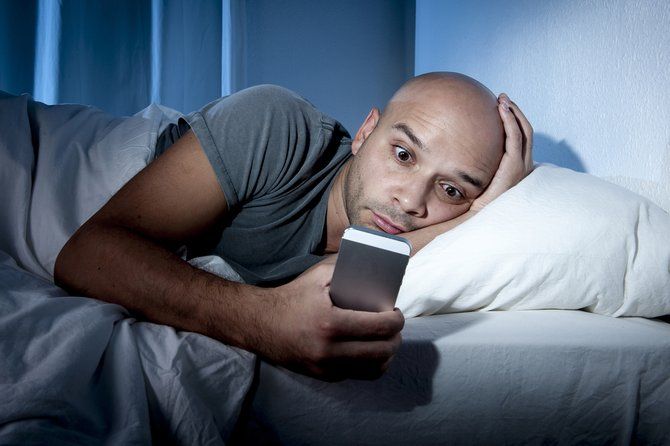 человек на смартфоне в постели